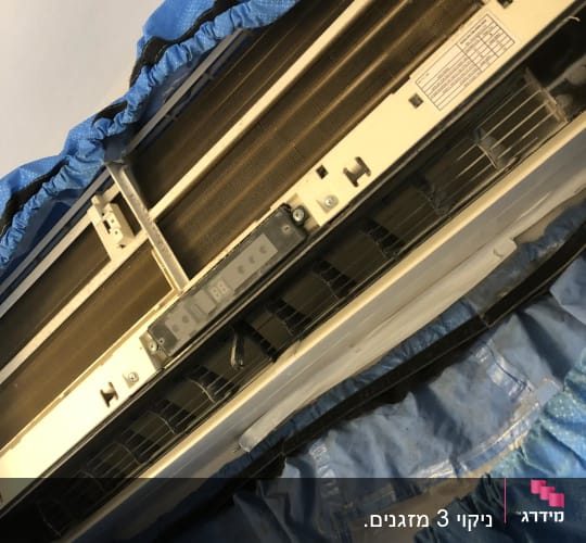 מזגן מפורק עם כיסוי כחול לתחזוקה